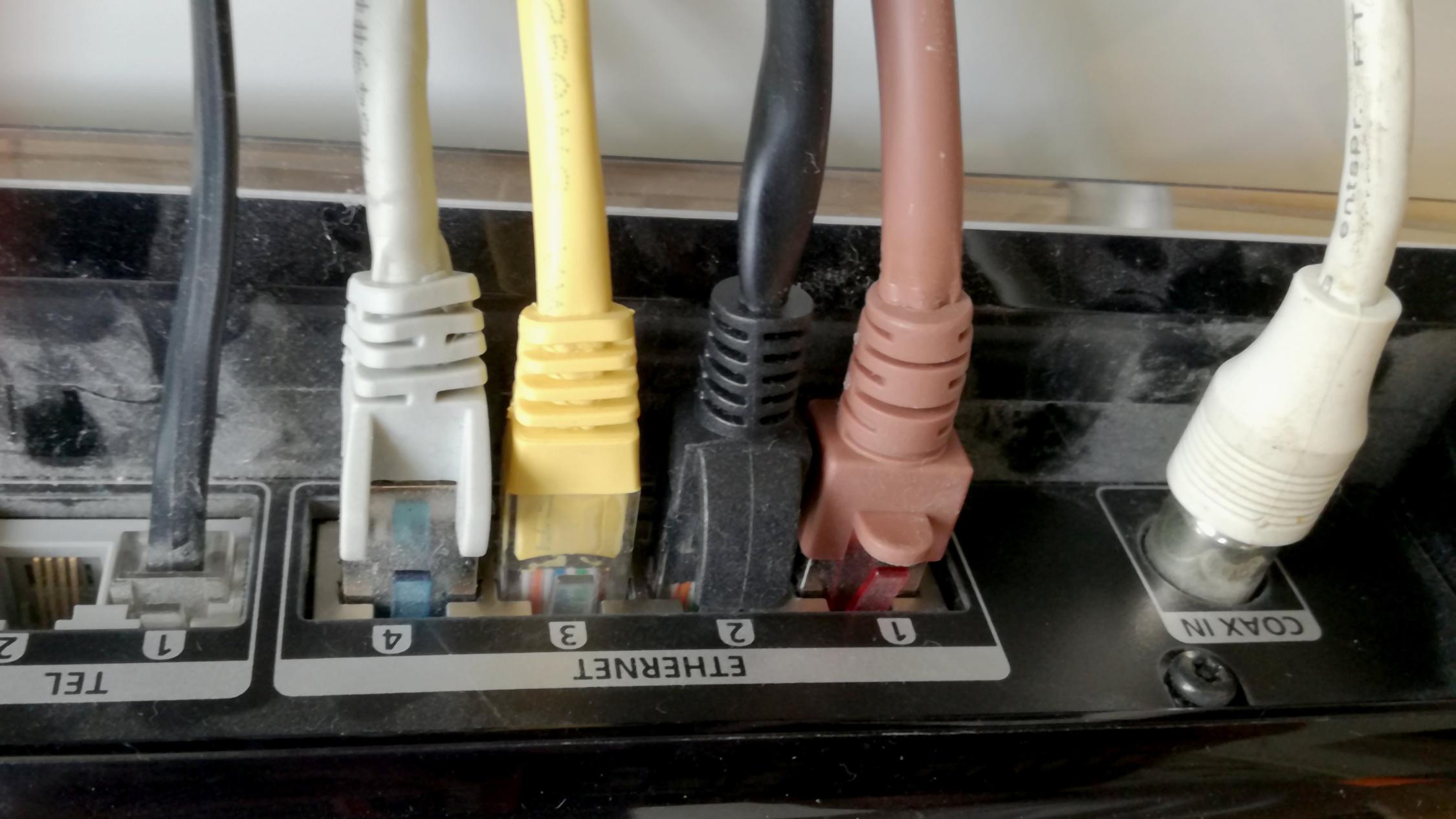 Mehrere farbige Netzwerkkabel sind in einen Router eingesteckt.